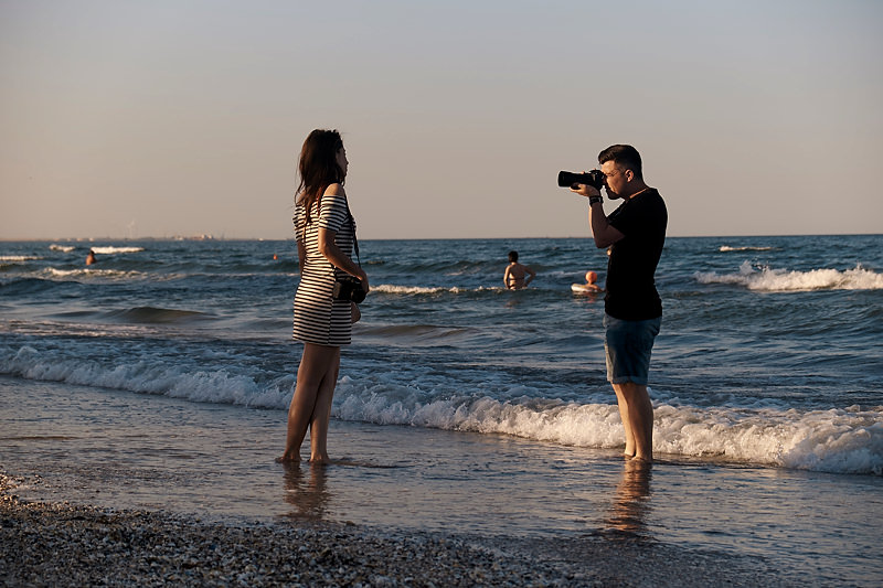 Videorgraf filmand o tanara pe plaja